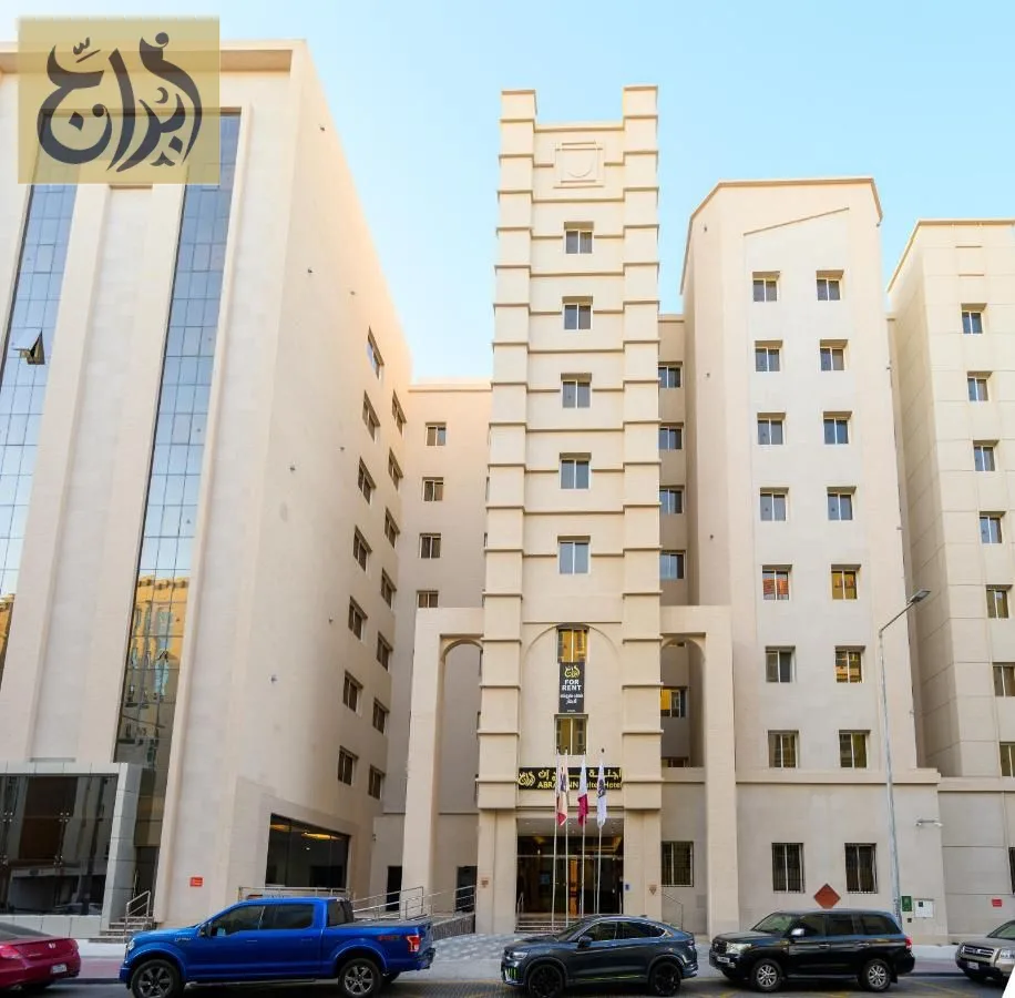 Exterior street view of the Abraj Suites Hotel building on Hisham Bin Oqba Street, Al Mansoura, Doha