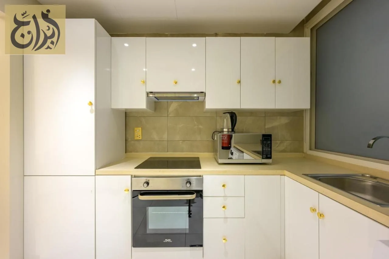 Fully equipped kitchen with oven, ceramic hob, kettle and coffee machine at Abraj Suites Hotel Doha