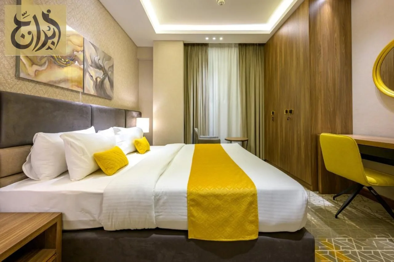 Bedroom with king bed and work desk in a long stay apartment at Abraj Suites Hotel Doha