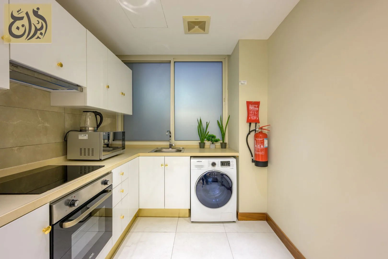 Fully equipped kitchen with oven, hob and washing machine at Abraj Suites Hotel Doha