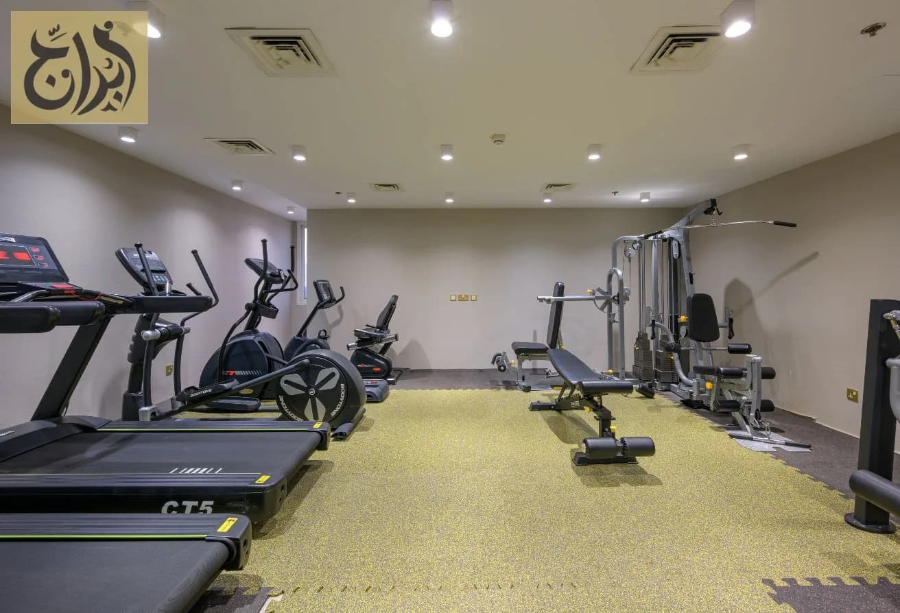 Gym with treadmills and cardio machines at Abraj Suites Hotel Doha