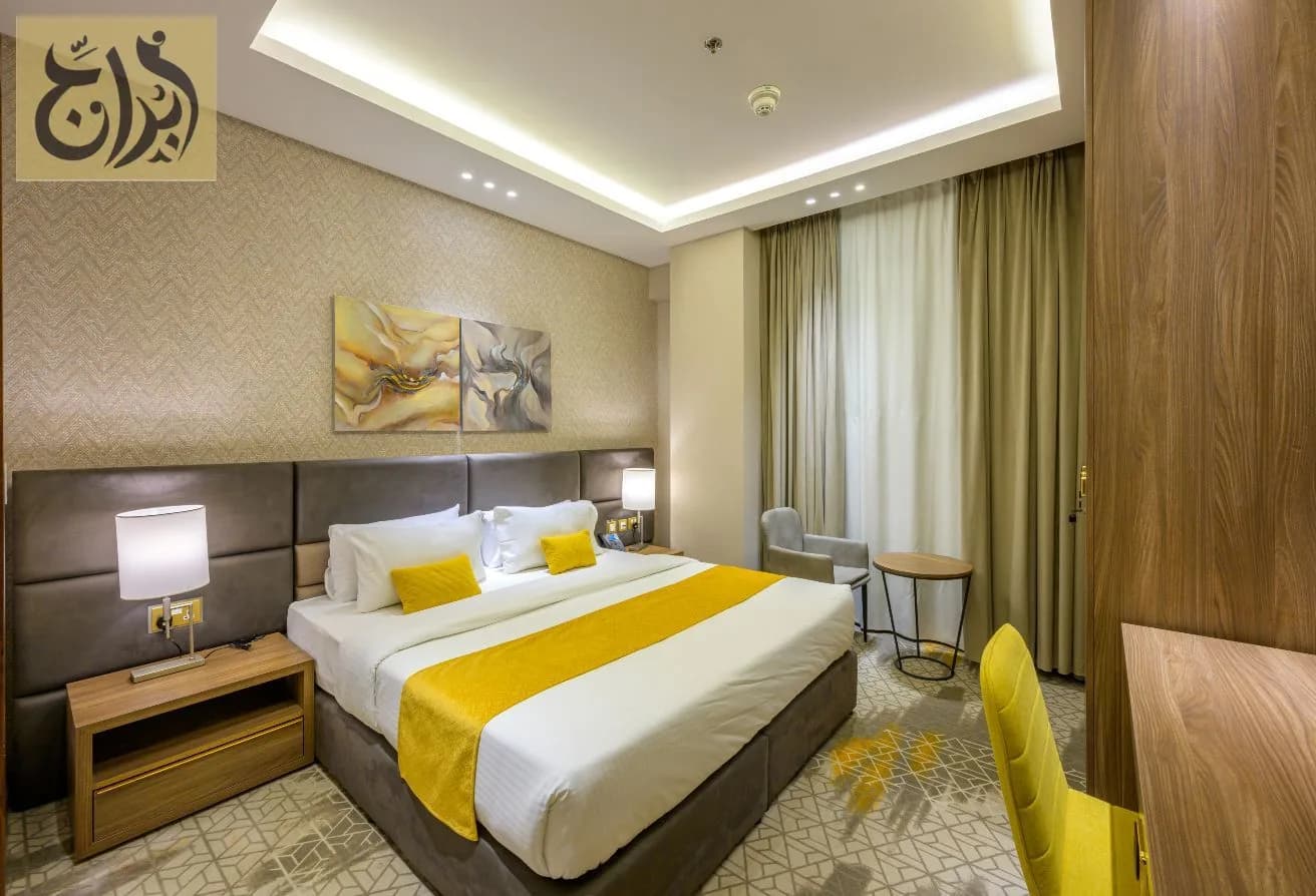 Suite bedroom with king bed and seating at Abraj Suites Hotel Doha